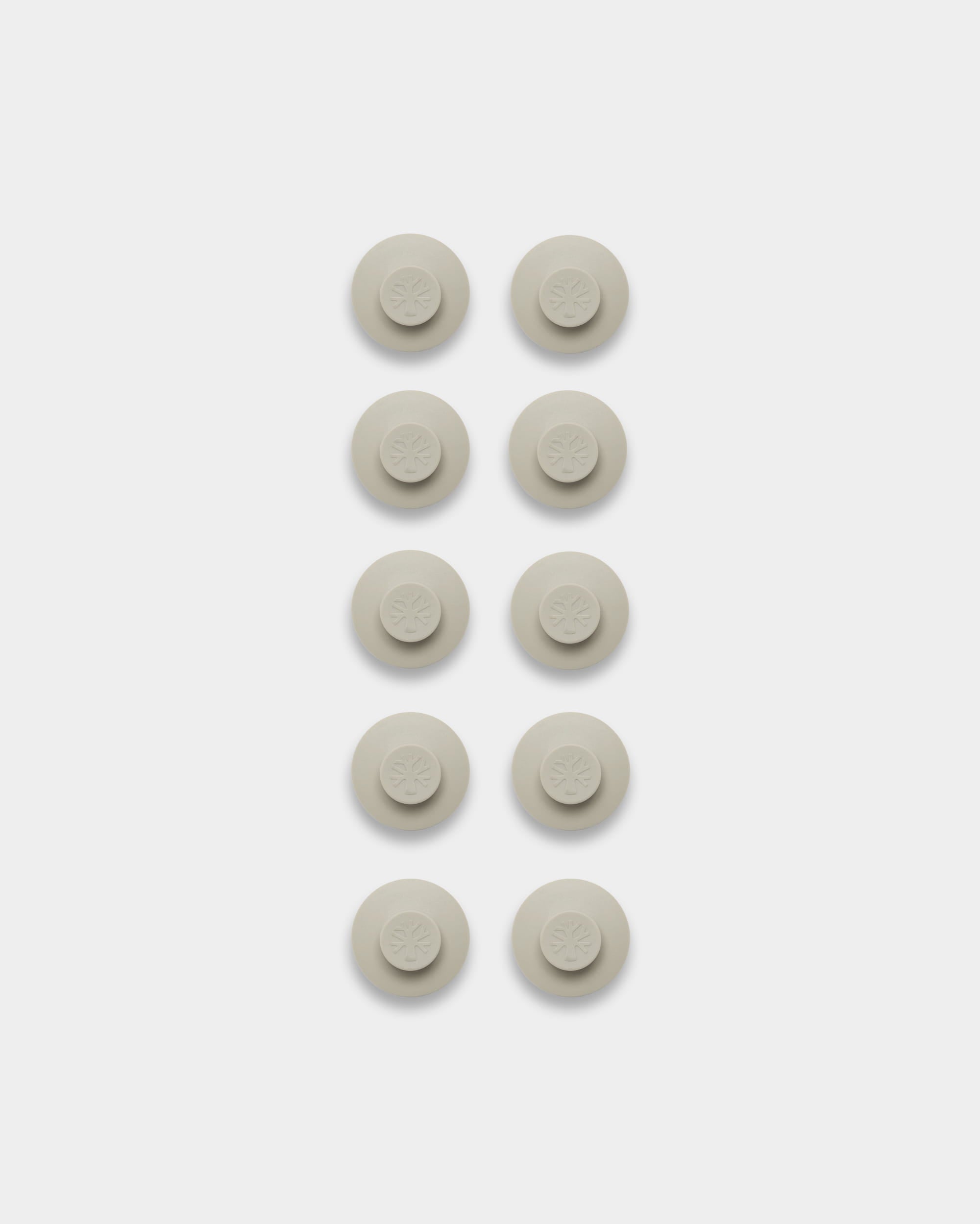 Ten light beige Dupps pads, arranged in two columns; accessory for mounting or organizing Akupanel acoustic panels.